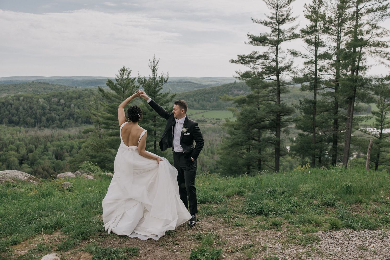 Mountaintop wedding ceremony with pine trees and rolling hills in the background.