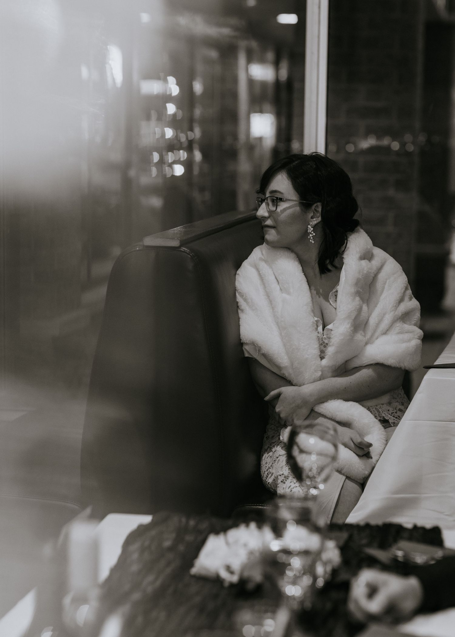 A black and white portrait of someone in formal attire with a white fur wrap at an evening event.