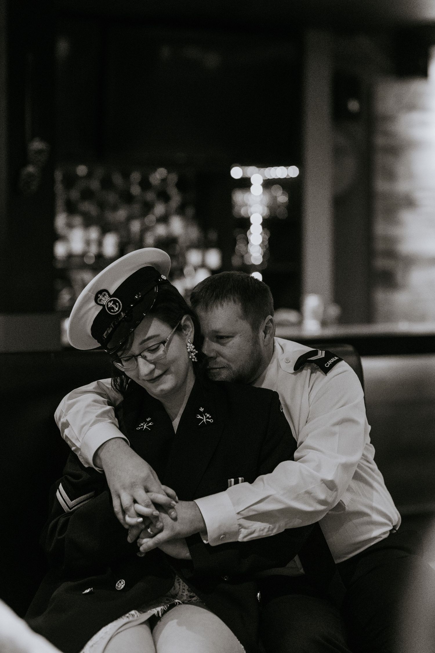 An intimate black and white moment between a couple in military-inspired formal wear.