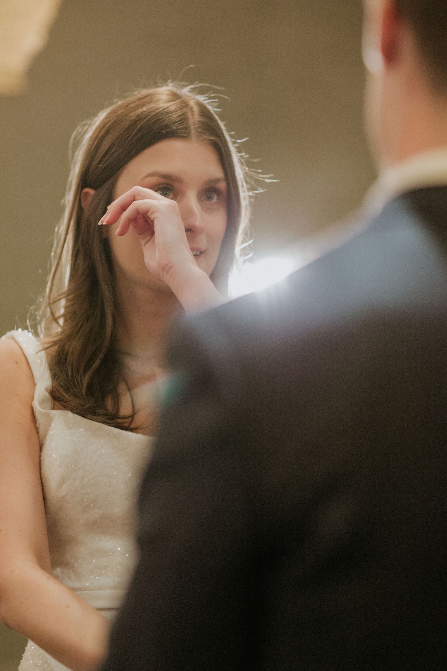 An emotional moment during a wedding ceremony as tears are wiped away.