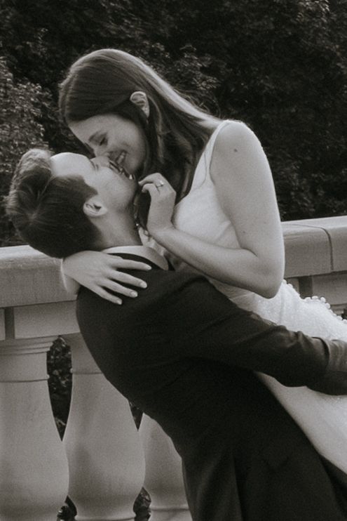 A romantic black and white photo sequence showing a couple sharing a tender kiss against a white railing.