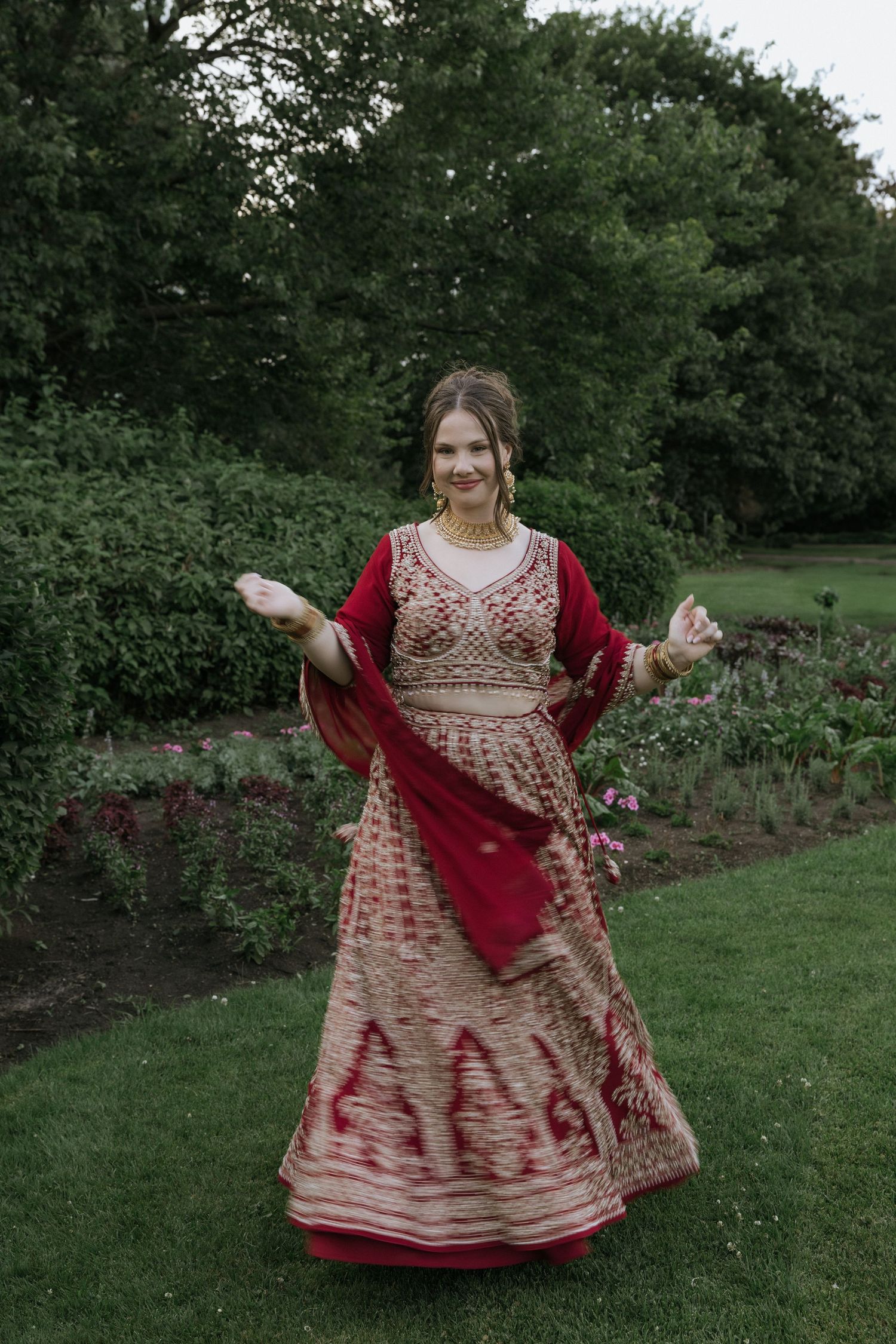A sequence of joyful poses in a traditional red and gold embroidered dress against a garden backdrop.