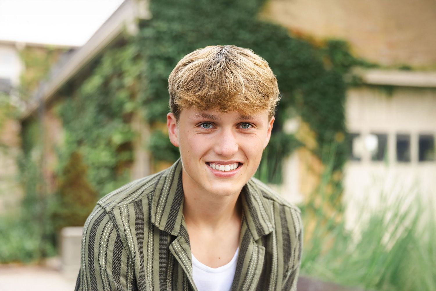Senior boy smiling at the camera in a downtown setting.