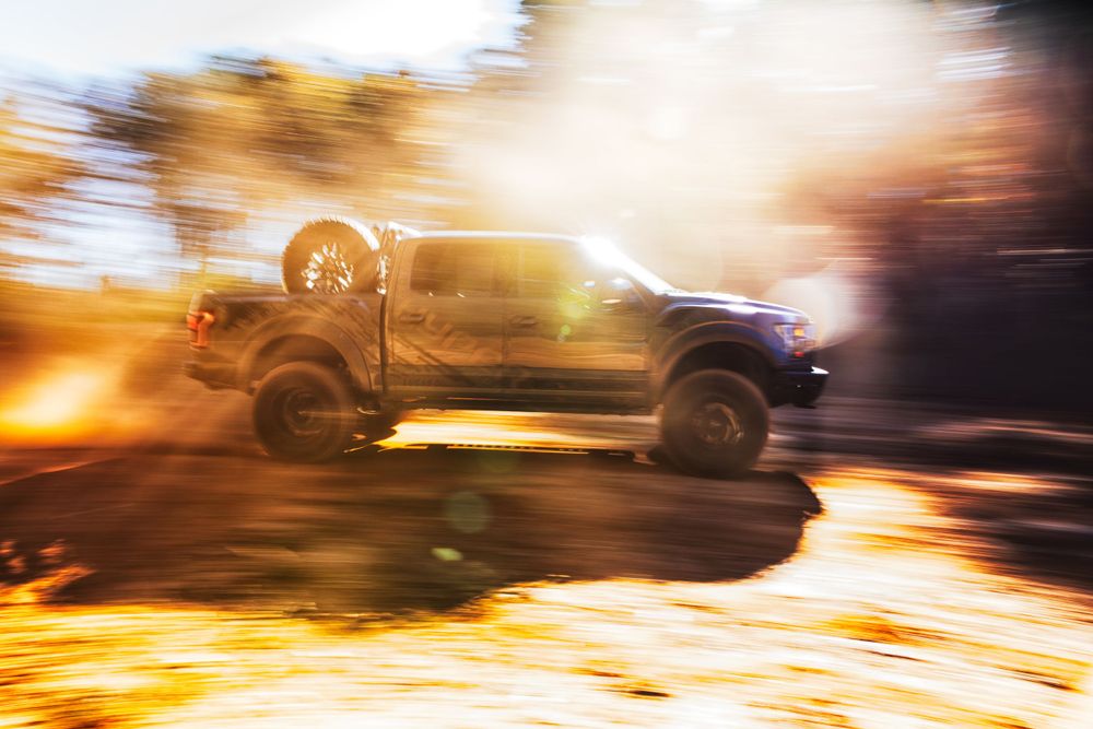 Motion blur photograph of vehicles creating light trails at dusk.