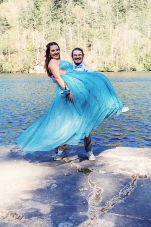 A playful photo sequence showing a turquoise dress flowing in the wind by a lake.
