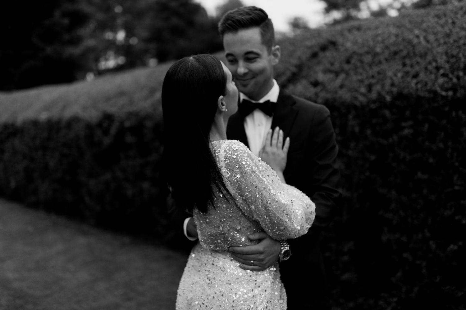 Outdoor wedding ceremony setup with two stone pillars and tall hedges creating an elegant backdrop.