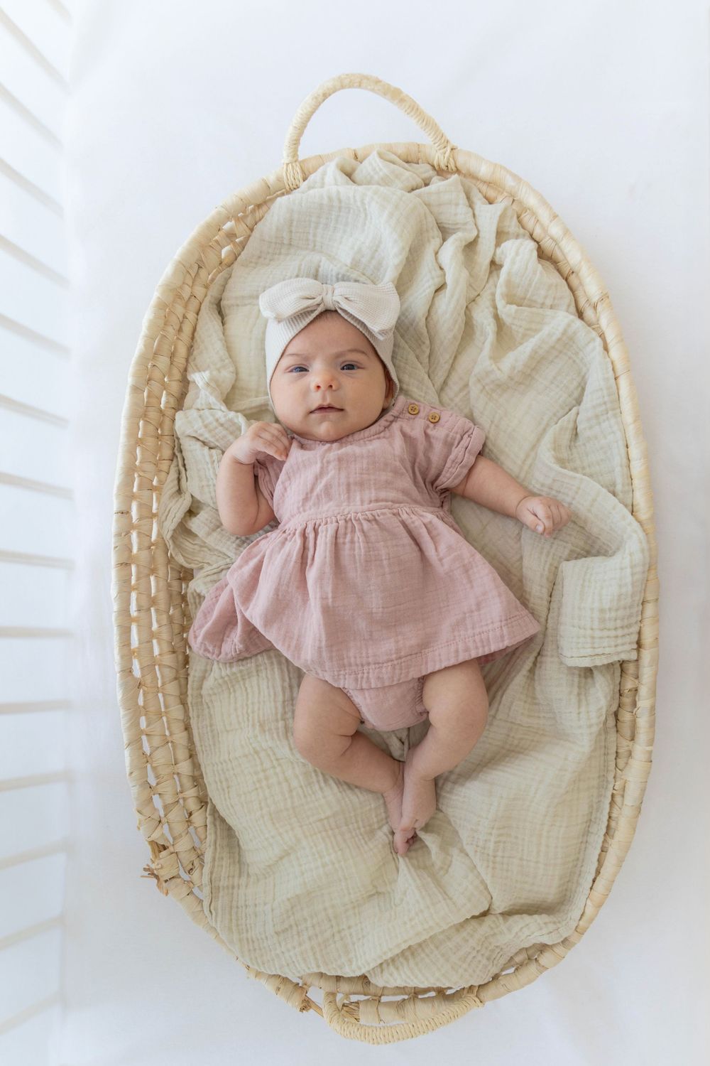 Newborn baby in a basket, in a crib.