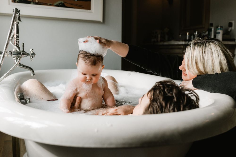 A playful bathtime moment captured in a white vintage bathtub.