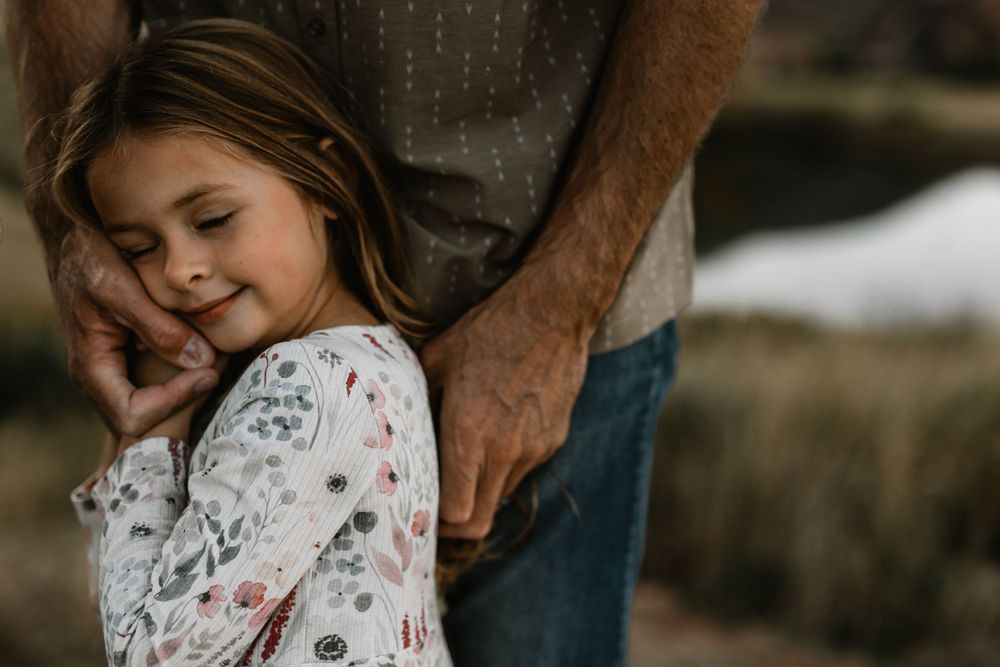 A tender moment captured between parent and child in soft natural lighting.