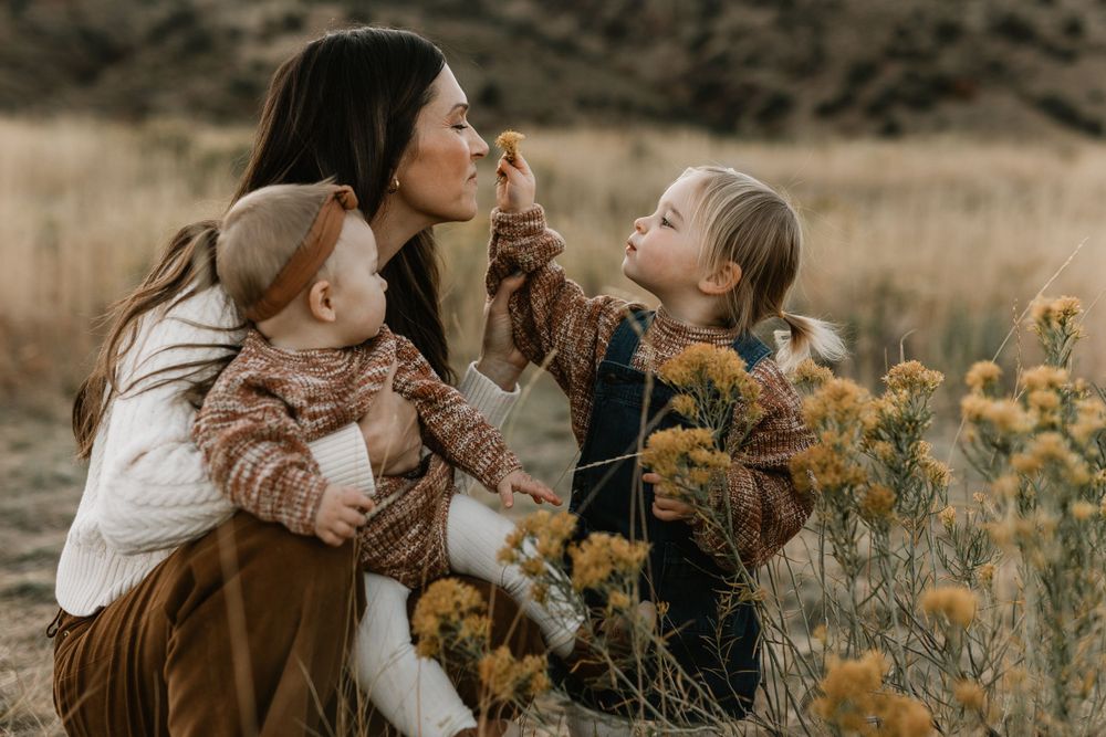 A tender moment shared among family members in a field of yellow wildflowers.