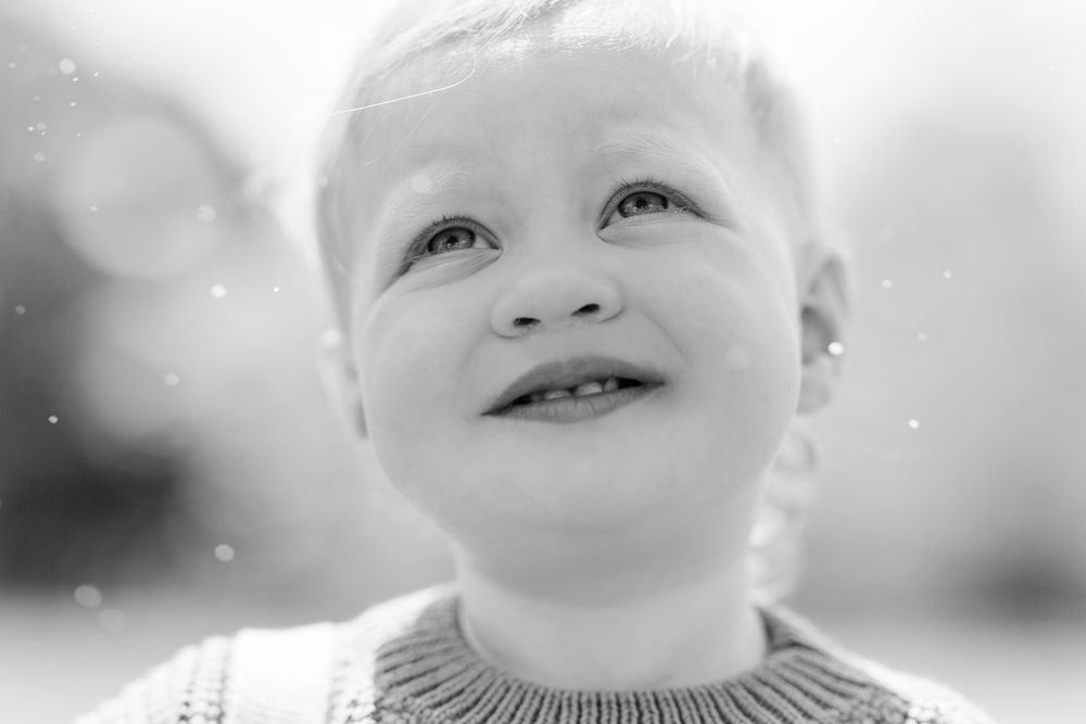 London, UK, family photography session in the park. Little girl looking up at the sky.