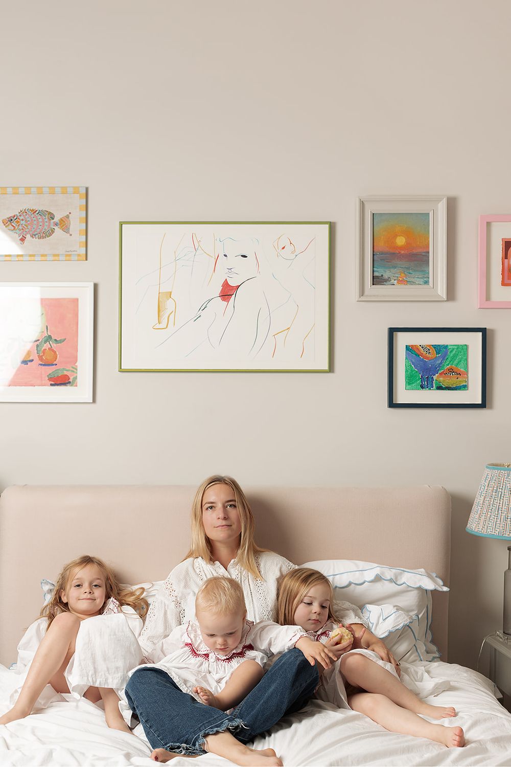 London, UK, motherhood photography session. Sisters wearing matching Smock London night dresses. Mum and her daughters sitting on the bed.