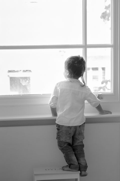 London, UK, in home family photography session. Capturing beautiful moments looking out the window.