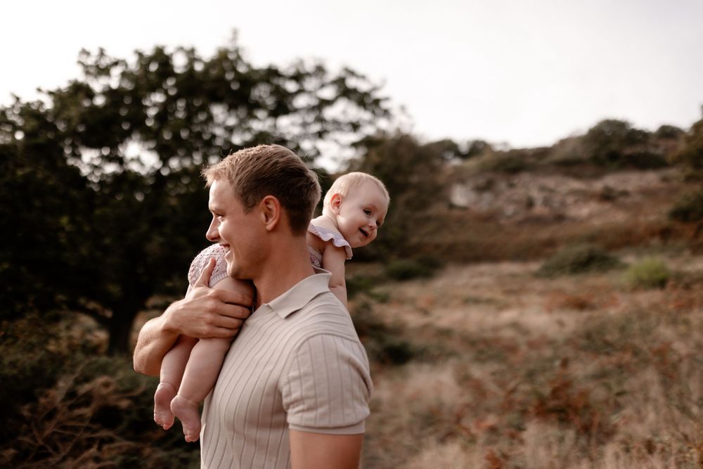 Candid family photography session captures sweet interactions in a natural outdoor setting.