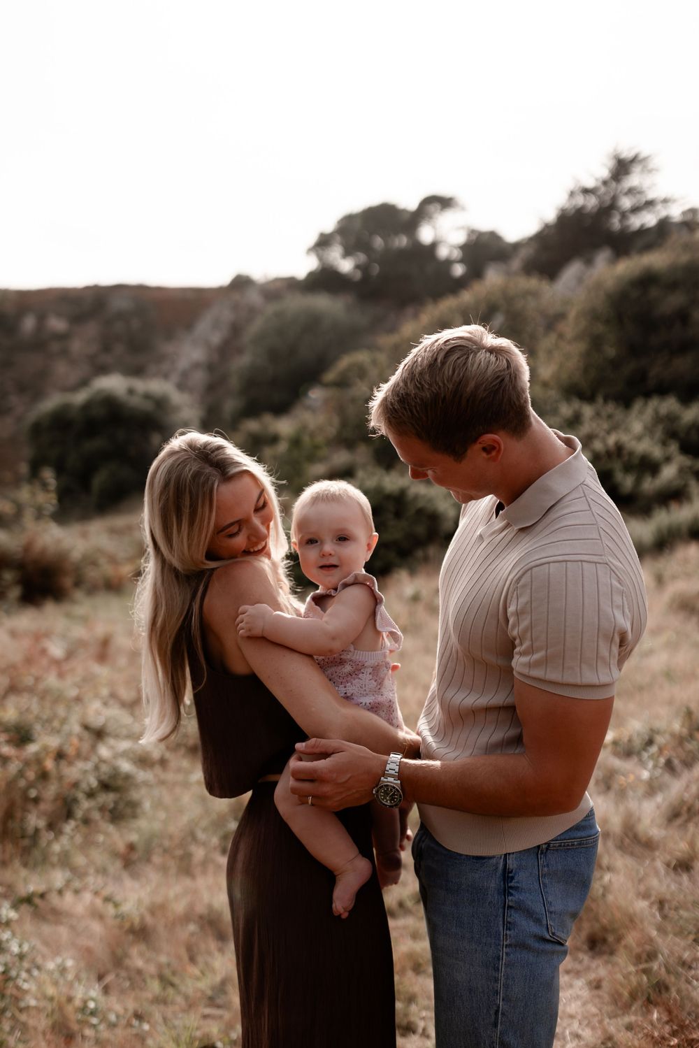 Heartwarming family moments unfold during an outdoor photoshoot in golden light.