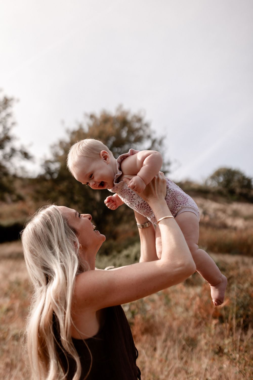 Joyful interaction captured during golden hour in a natural outdoor setting.