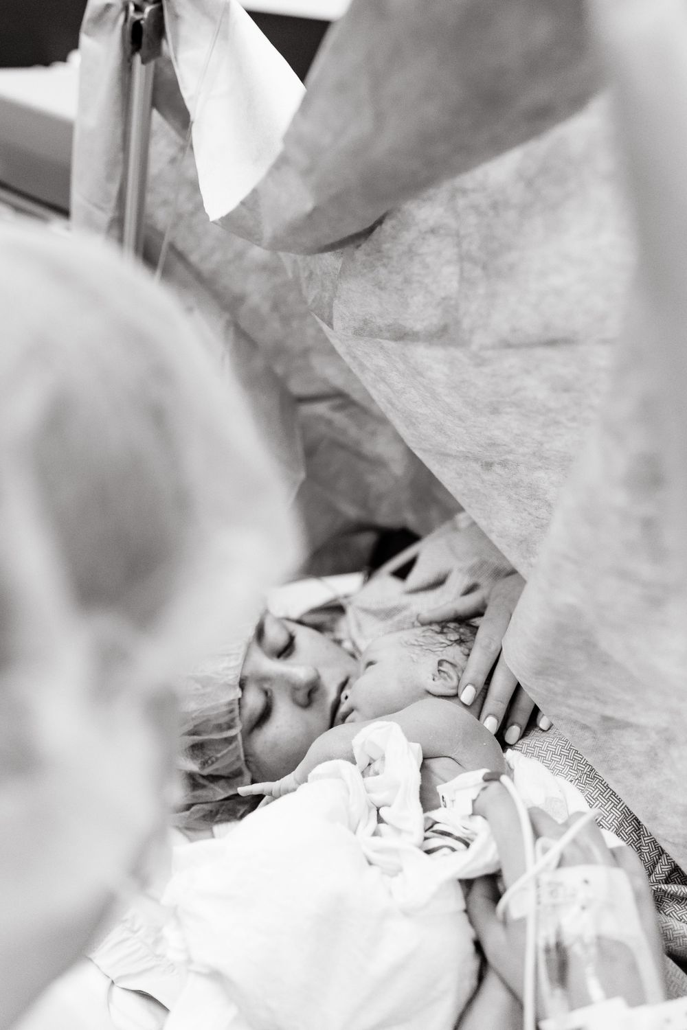 Black and white medical image showing a patient receiving care in a hospital bed with medical equipment visible.