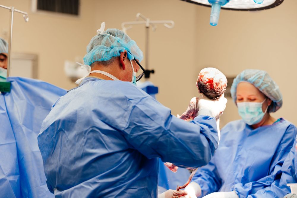 Doctors and nurses work together during surgical delivery in hospital operating room.