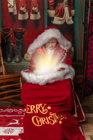 Christmas themed display with glowing red velvet sack featuring 'Merry Christmas' text and decorative elements.