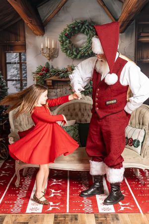 Series of images in Christmas setting showing red dress twirling against snowy backdrop with festive holiday decor.
