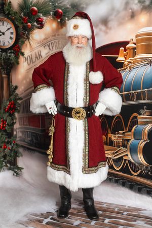 Santa Claus in elegant red velvet suit with gold trim stands before a vintage Polar Express train in a festive Christmas scene.
