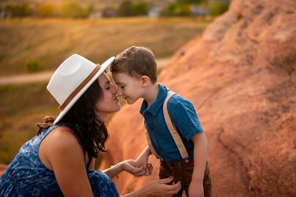 A touching outdoor moment captured at sunset against red rock formations in warm golden light.