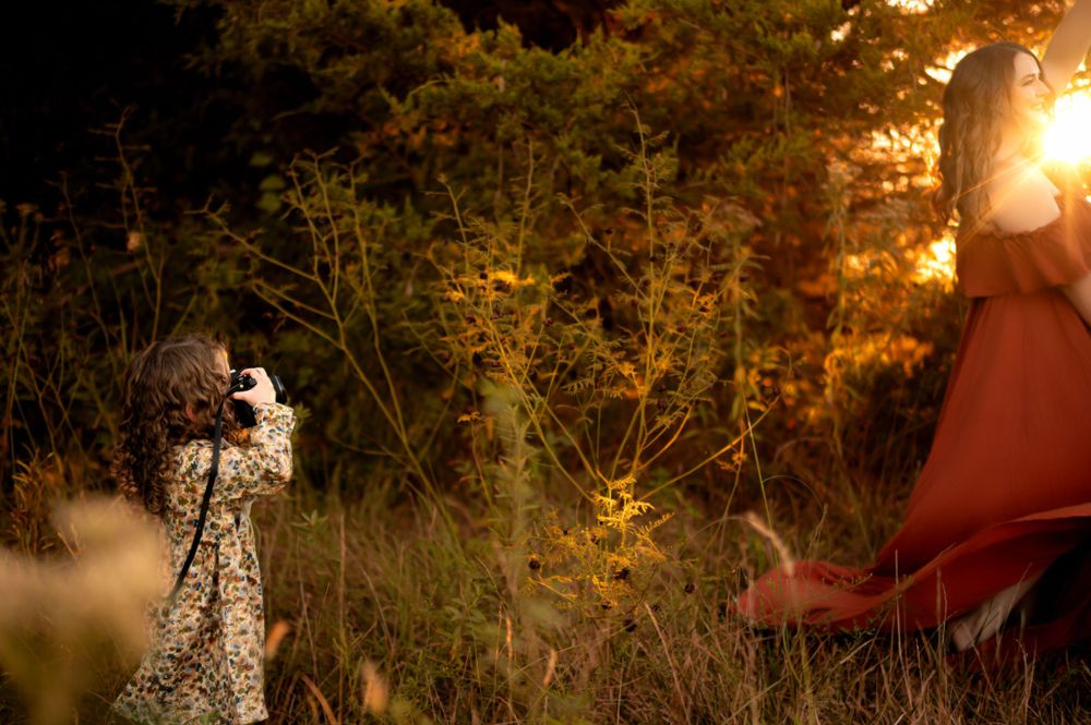 A glimpse of white and red dresses illuminated by golden sunlight filtering through trees at dusk.