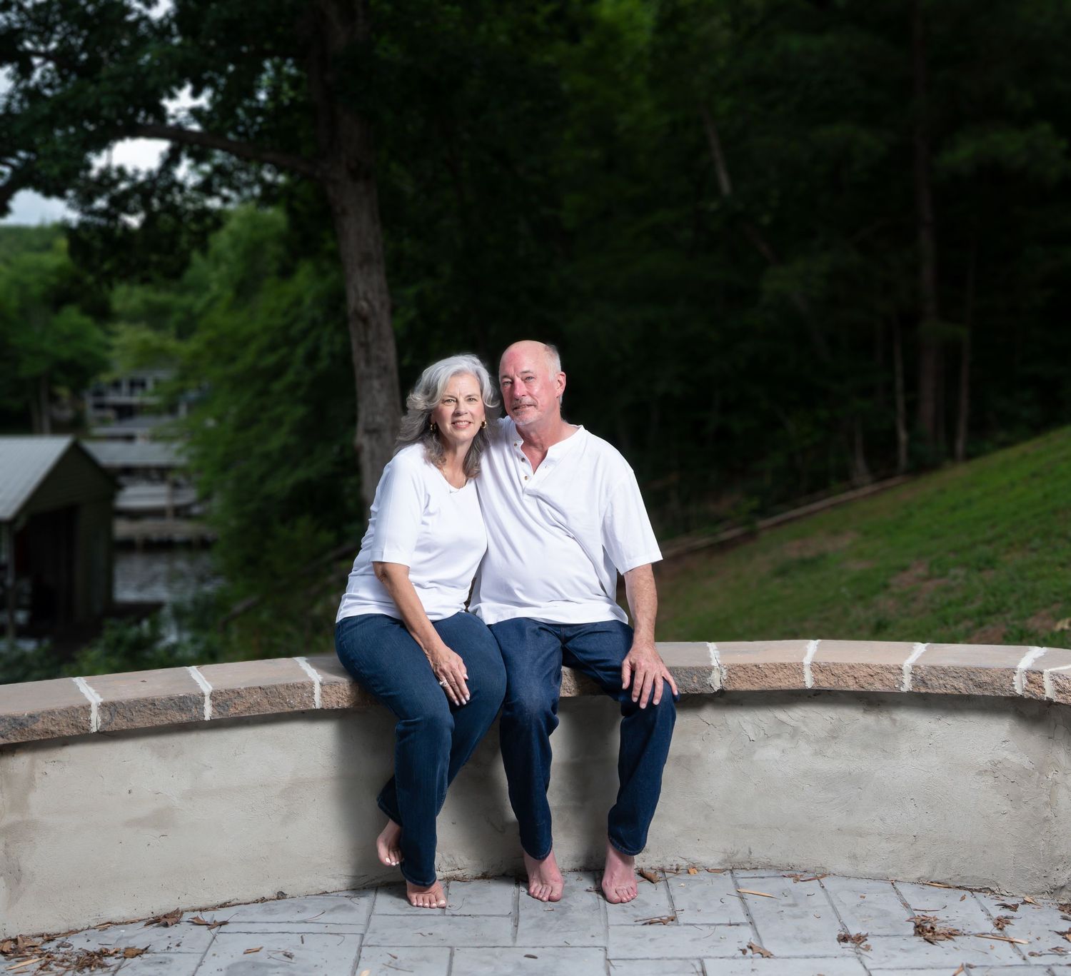 Extended family portrait session on outdoor stone steps in coordinated white and denim outfits.