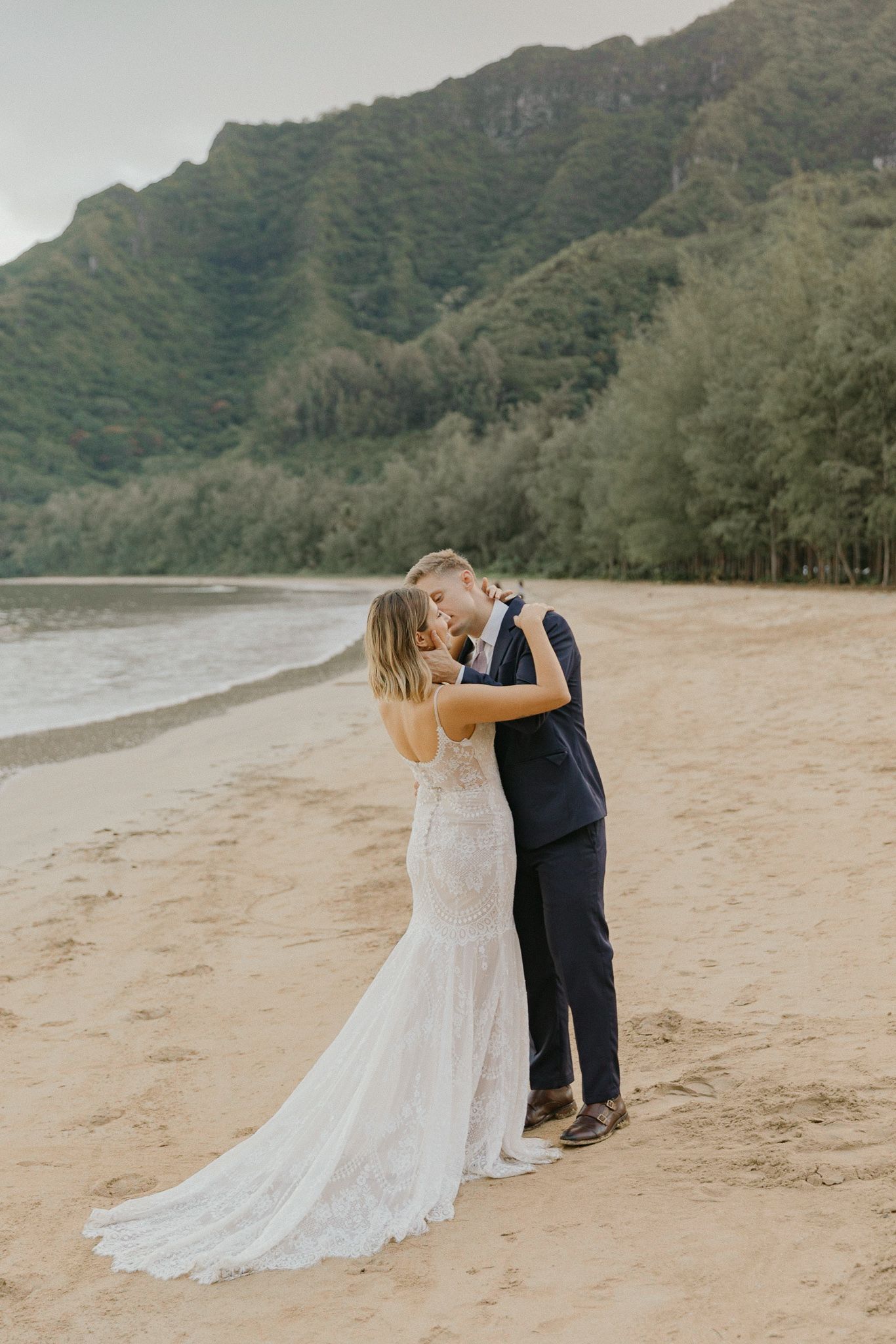 Orlando luxury wedding photographer capturing love on a beach with mountains in the background.