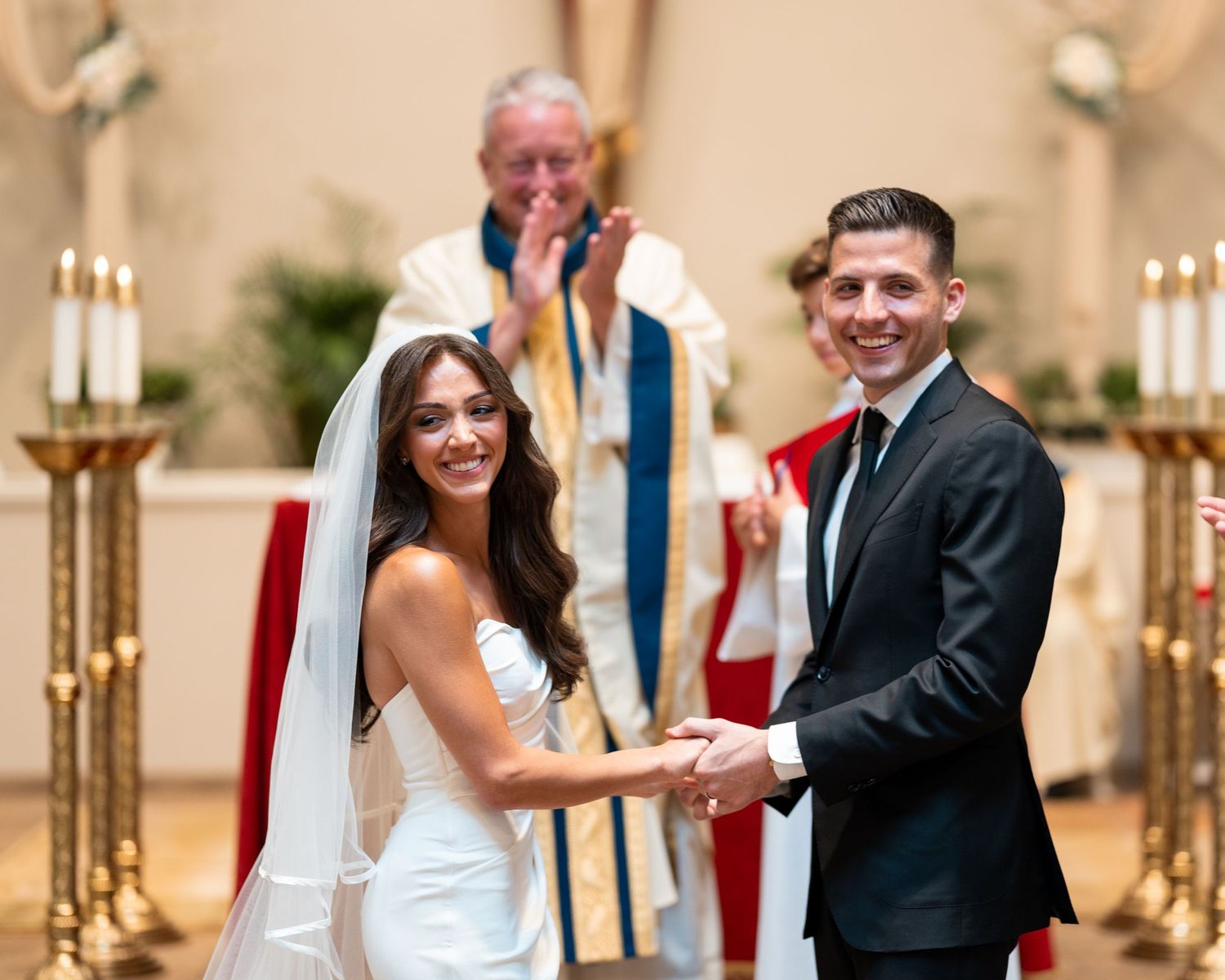 Elegant wedding ceremony in a traditional church with candlelit aisle and classic decor.