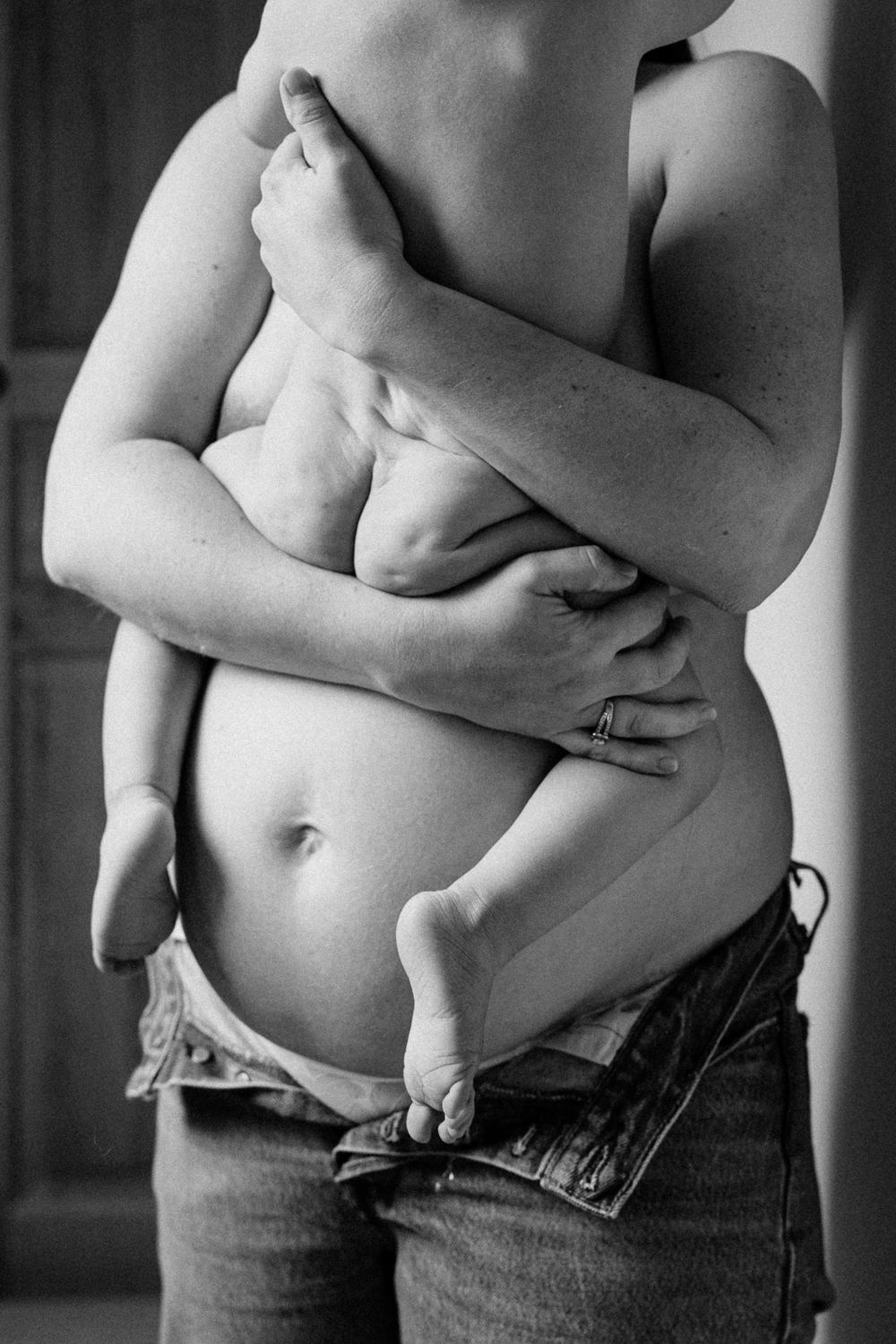 ventre rond d'une femme enceinte portant son fils aine en peau a peau dans ses bras, une image de maternite douce tendre et authentique