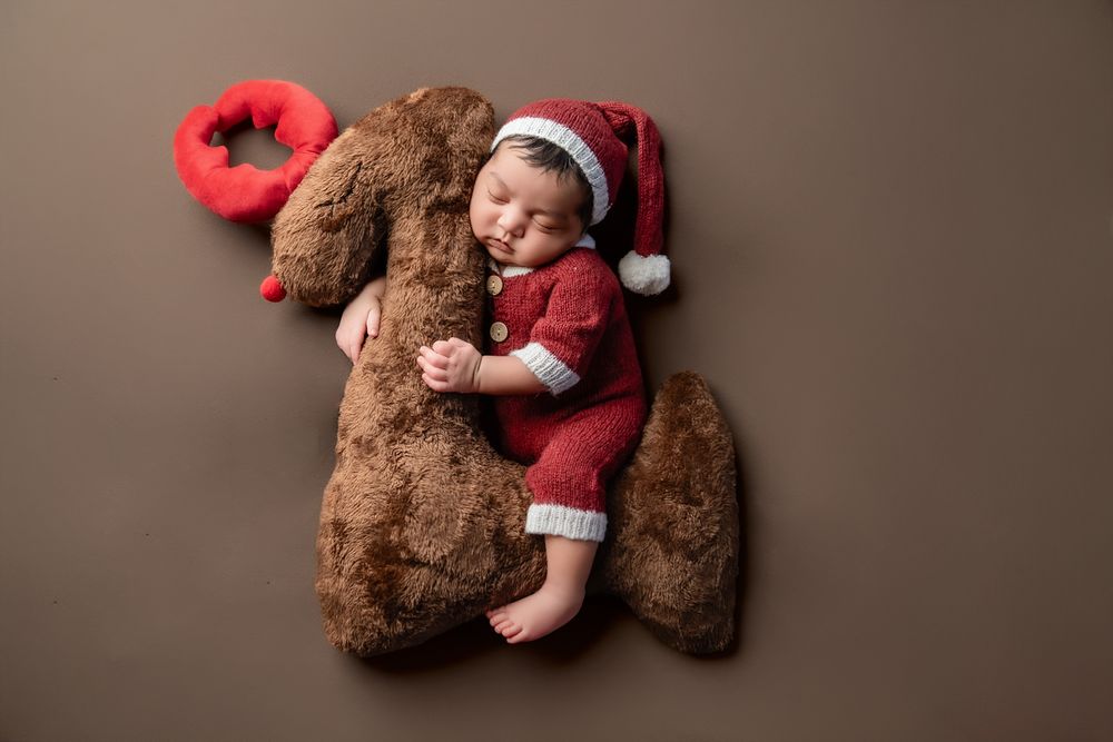 A collection of seven photos showing a brown teddy bear and small red Christmas decorations arranged in different poses.