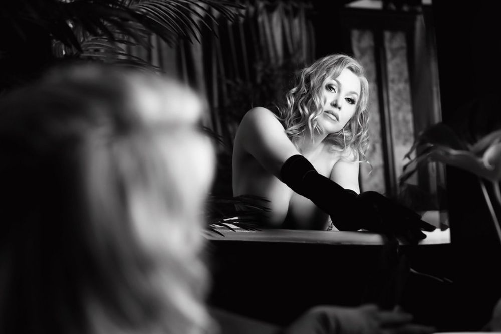 A person performs on stage in dramatic black and white lighting during a theatrical performance.