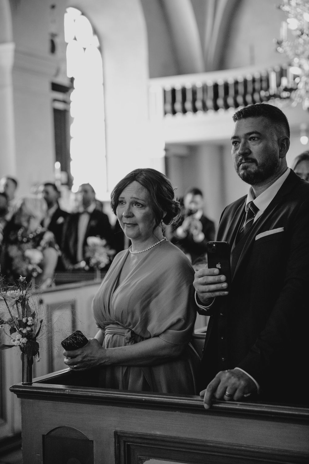 Bröllopsfotograf tar bilder på brudpar under vigsel i Mariefreds kyrka i augusti
