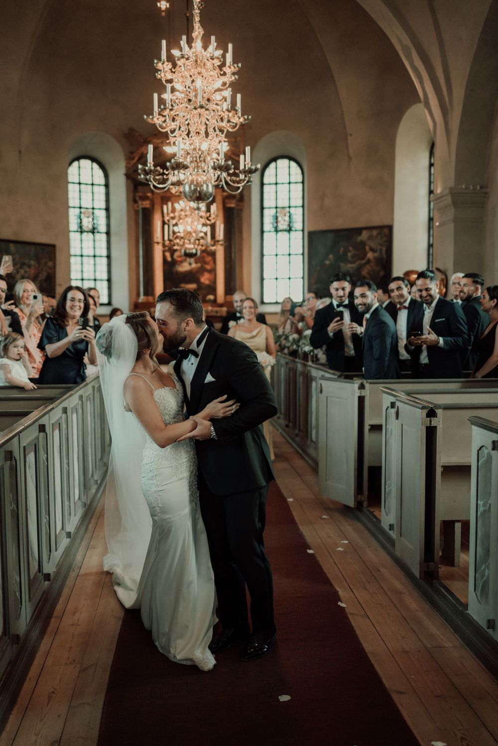 Bröllopsfotograf tar bilder på brudpar under vigsel i Mariefreds kyrka i augusti
