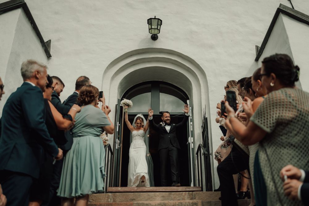 Bröllopsfotograf tar bilder på brudpar under vigsel i Mariefreds kyrka i augusti