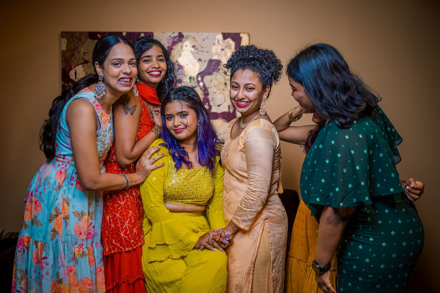 Group wearing colorful traditional outfits gathered together for a celebratory photo.