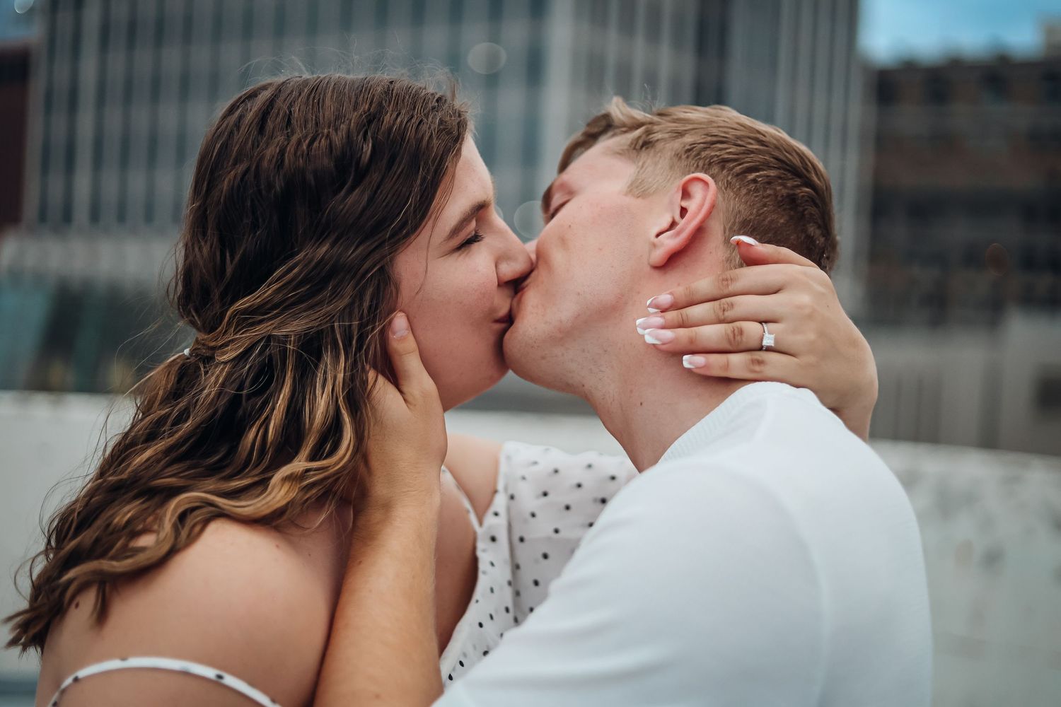 Intimate rooftop moment between newlyweds in urban setting. Engagement photography