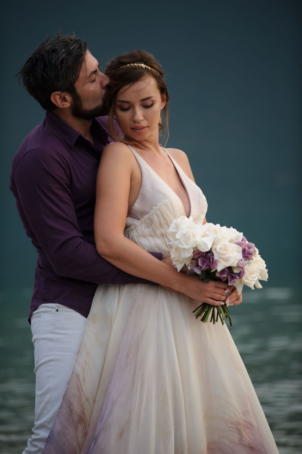 Romantic wedding couple embracing near water, natural light wedding photography