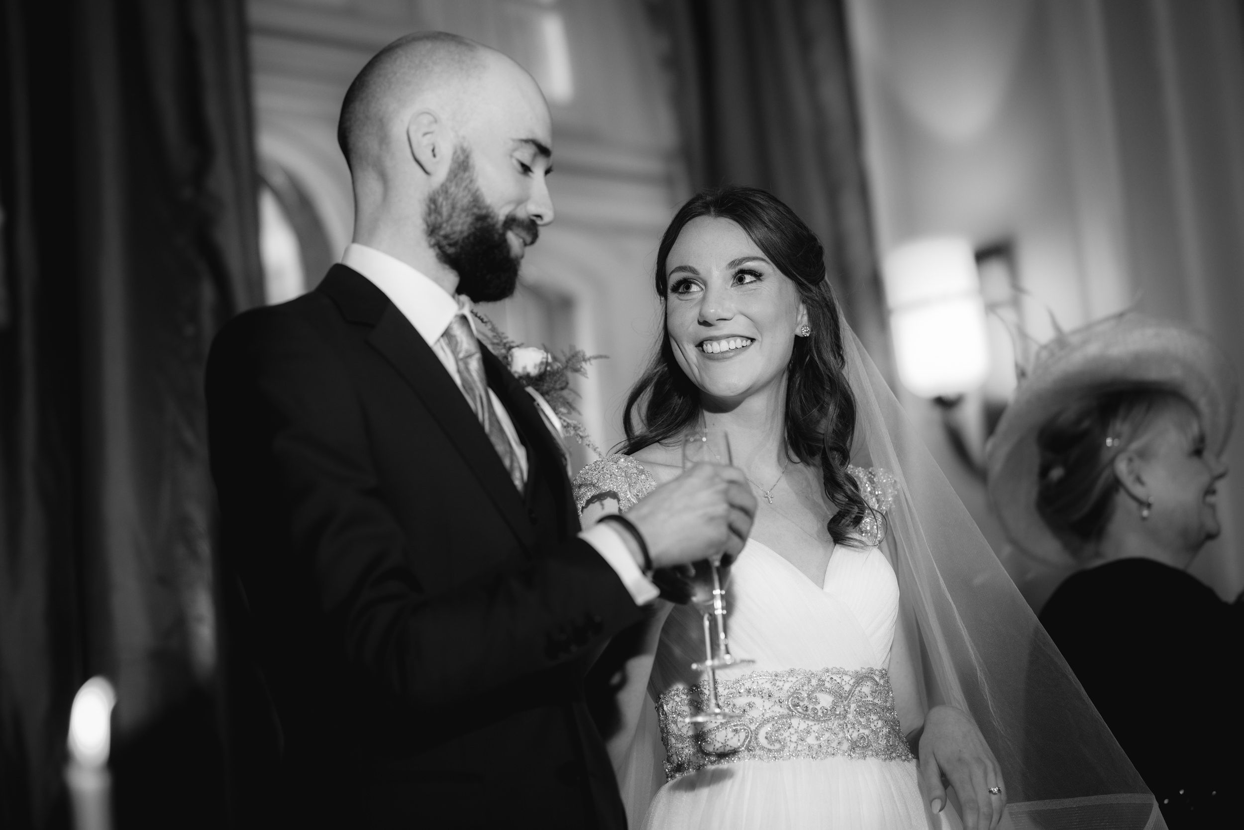 A romantic black and white photo of a bride and groom sharing a tender moment during their wedding celebration.