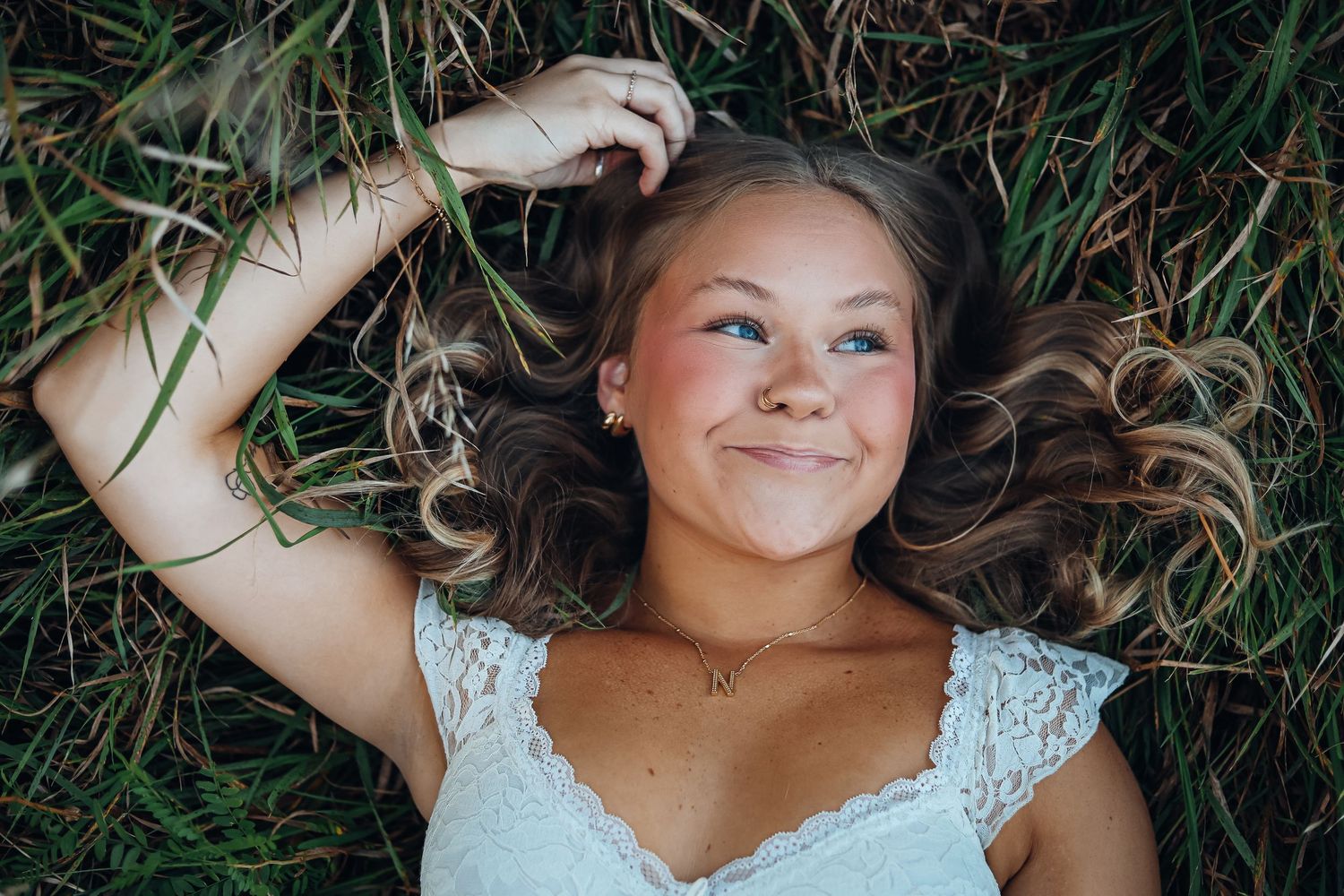 Portrait session in tall grass with natural lighting and dreamy atmosphere. Senior photography