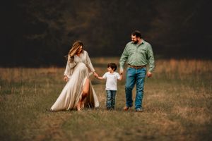 A dreamy photoshoot on a golden field at sunset shows intimate moments between people in casual attire.
