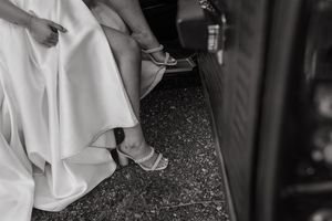 Black and white view of formal dress and heels on speckled carpet floor at an elegant event.
