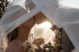 An artistic close-up shot of a wedding veil backlit by golden sunlight.