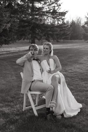 Romantic black and white photo series of a couple seated at a table outdoors on their wedding day.