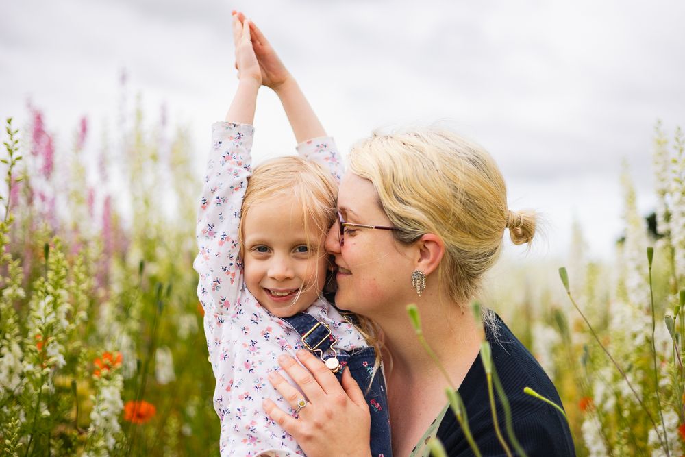 Portrait photo of a mother and daughter amongst wild flowers.