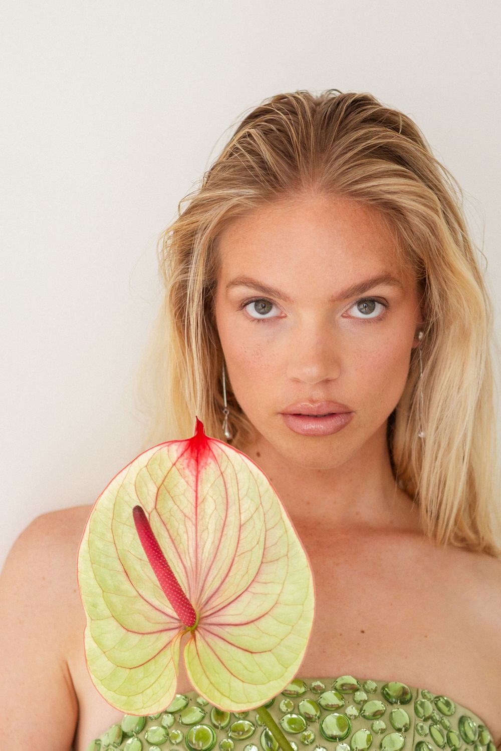 A close-up beauty shot featuring a pale green anthurium flower as a creative natural accessory.
