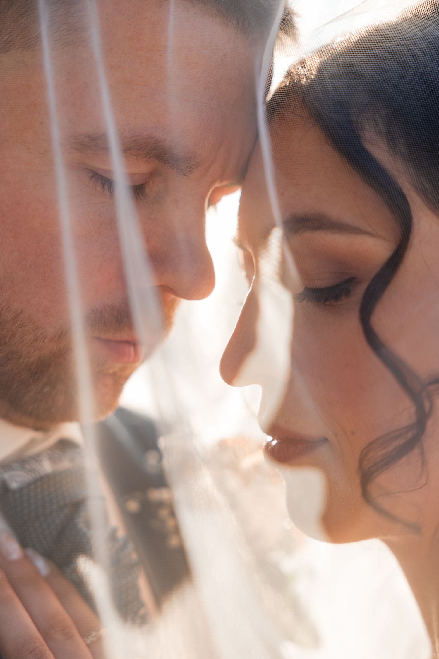 Hochzeitspaar unter dem Schleier in Neustadt-Glewe beim Paarshooting im Sonnenuntergang im Herbst, Brautpaarshooting Mecklenburg-Vorpommern
