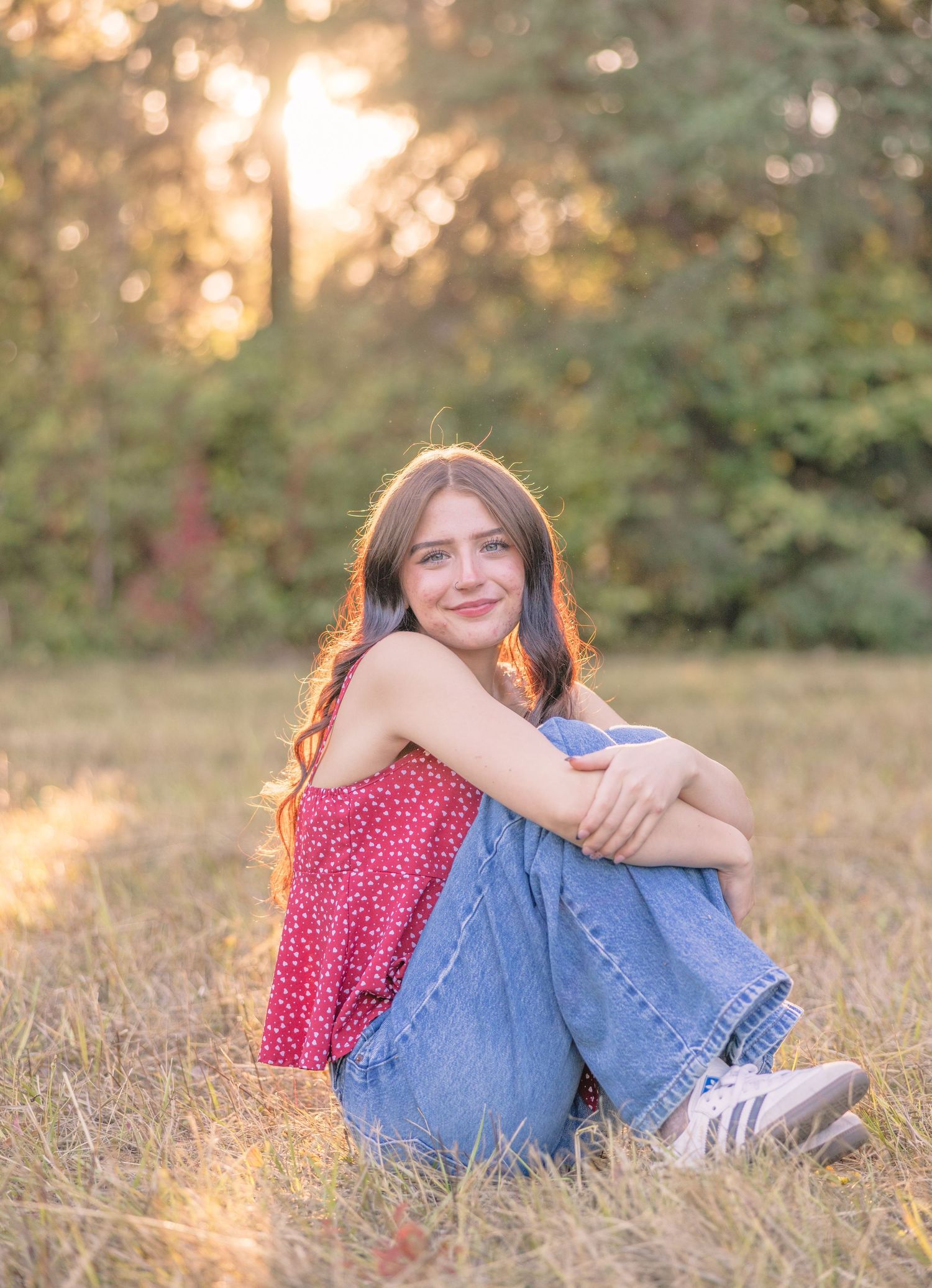 Casual outdoor portrait session in a sun-lit field during golden hour.