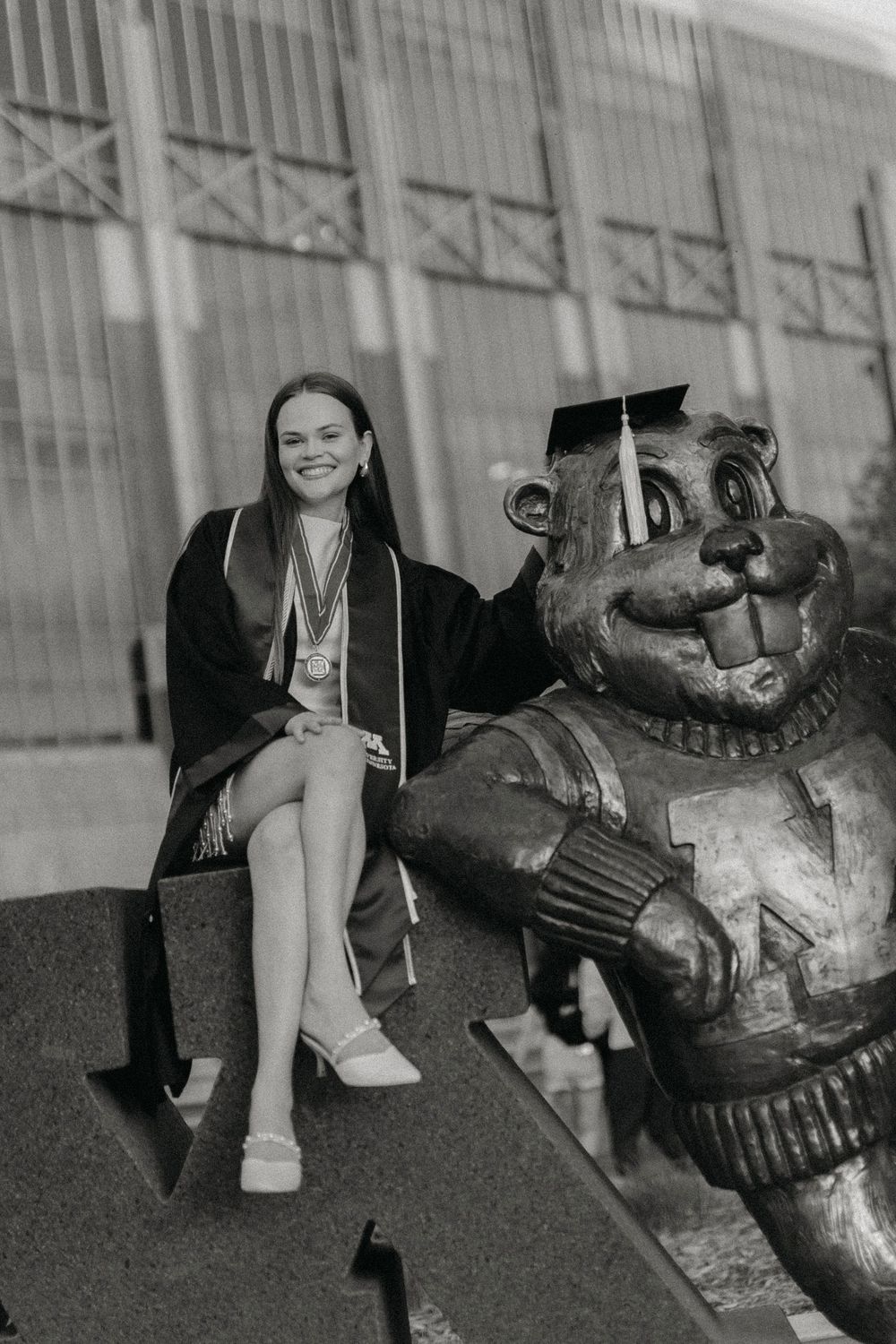 A student poses with the Goldy Gopher mascot statue at the University of Minnesota.